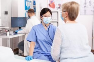 Nurse consulting senior patinet heart during health check up