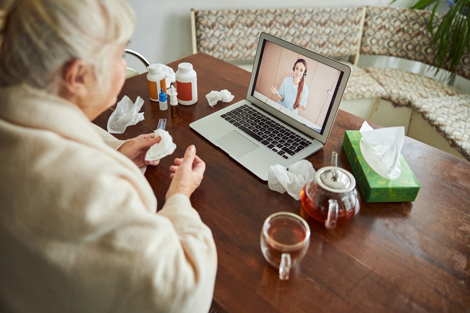 Sick old woman talking with doctor through video call